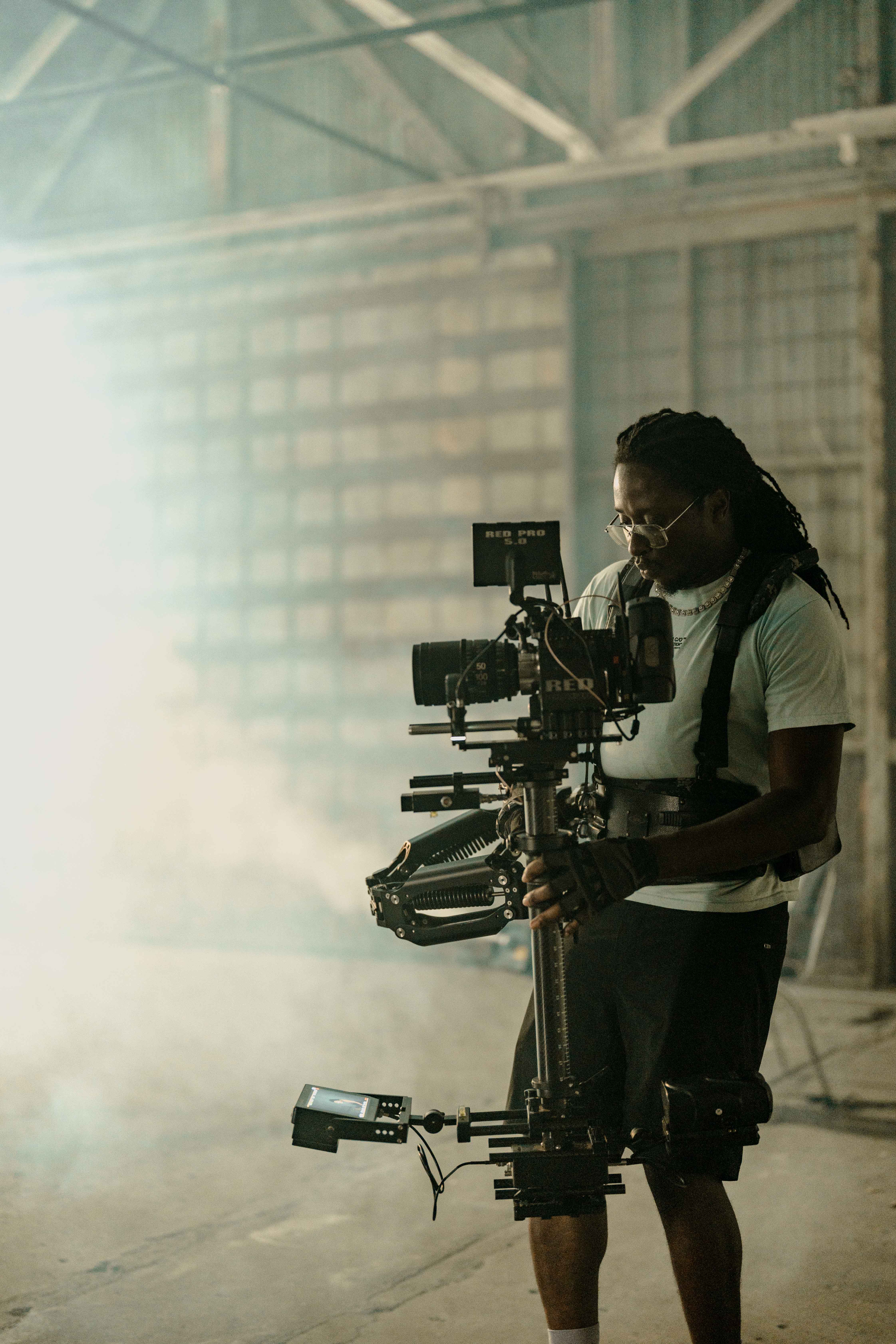 Camera operator working with a cinema rig on the warehouse set.