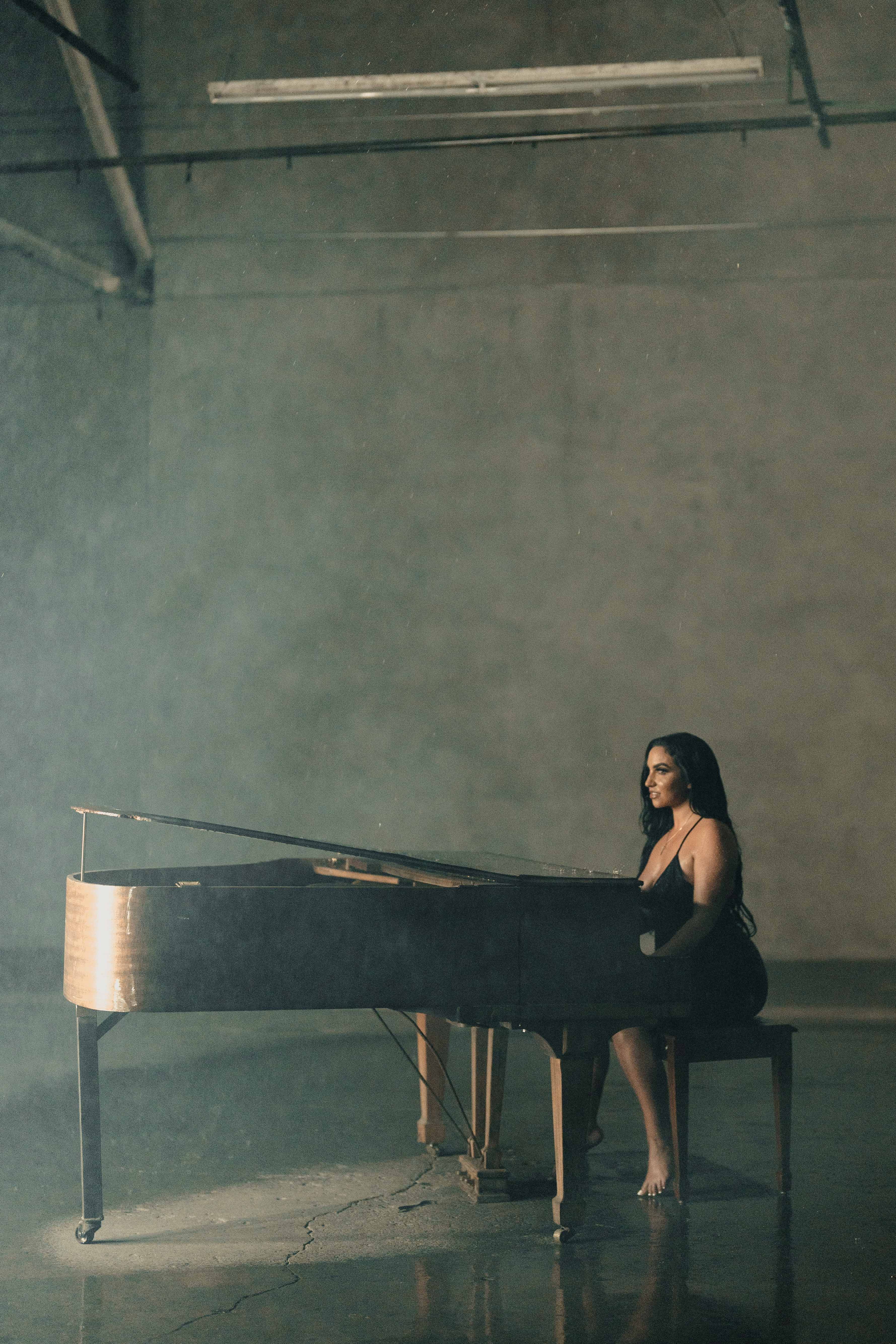 Wide portrait of Bianca at the grand piano in soft haze.