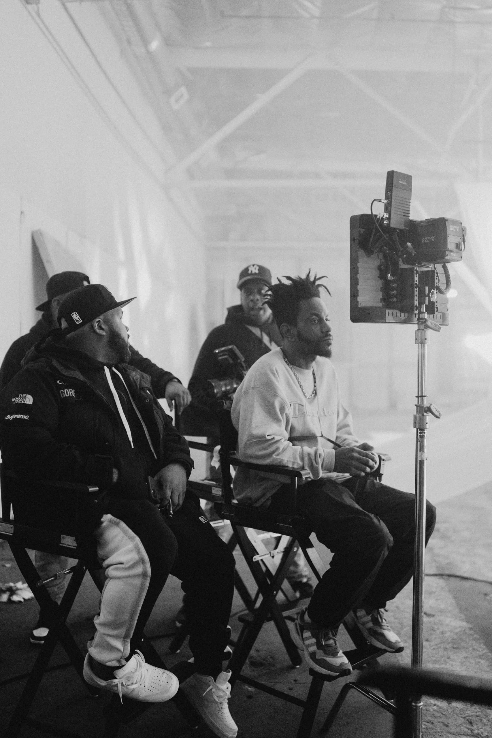 Black-and-white photograph of crew members watching a production monitor.
