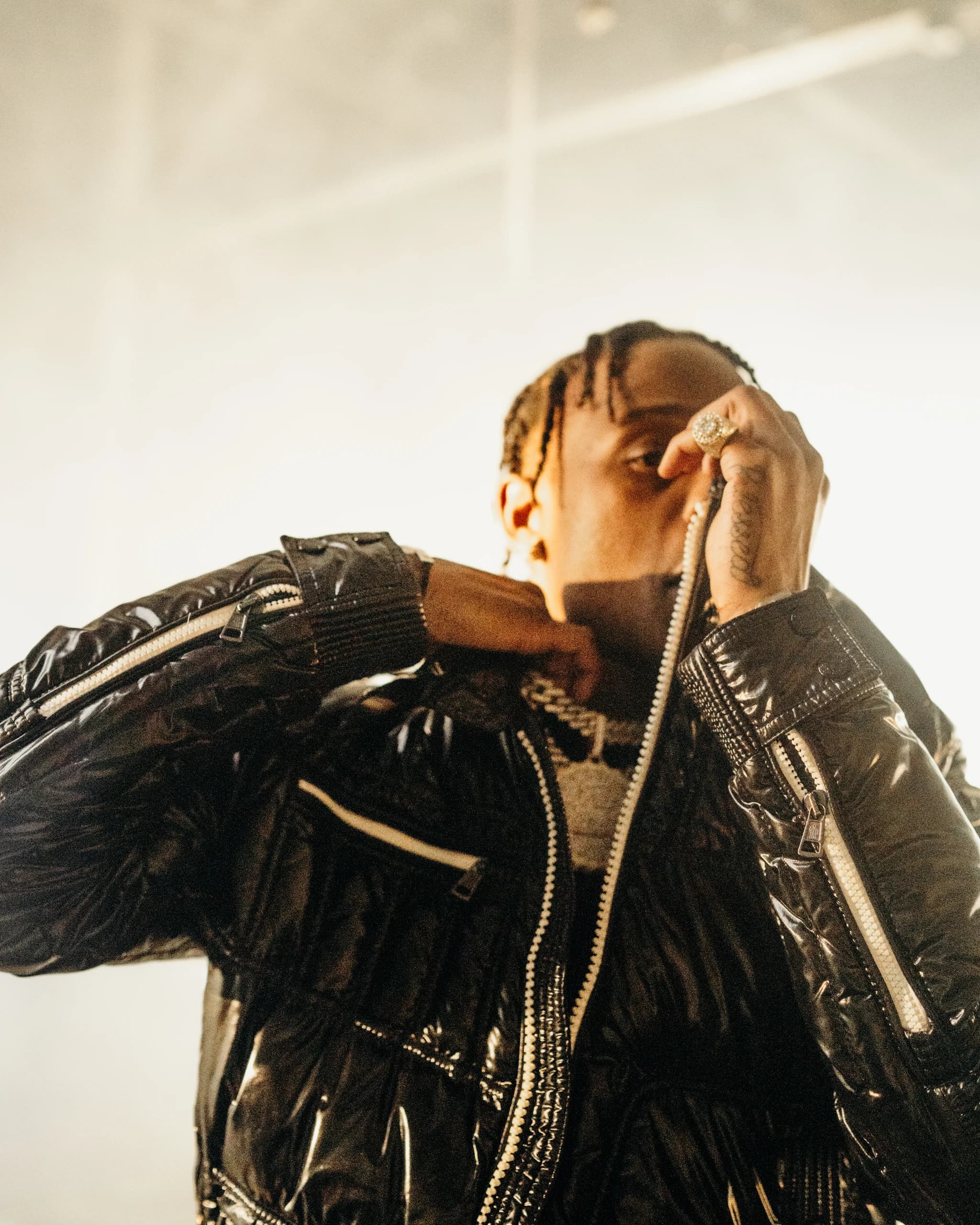Close-up of a performer lifting his jacket collar in warm light.