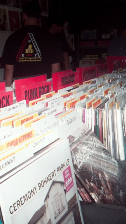 Rows of vinyl records and category dividers inside a record shop.