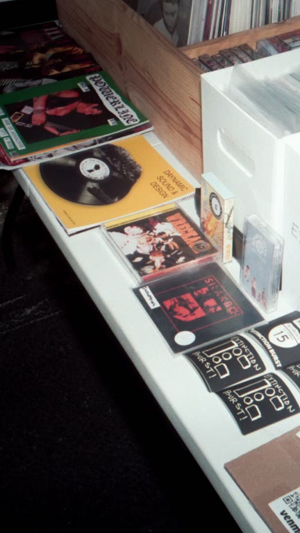 A closer look at records, tapes, and stickers on a shop display.